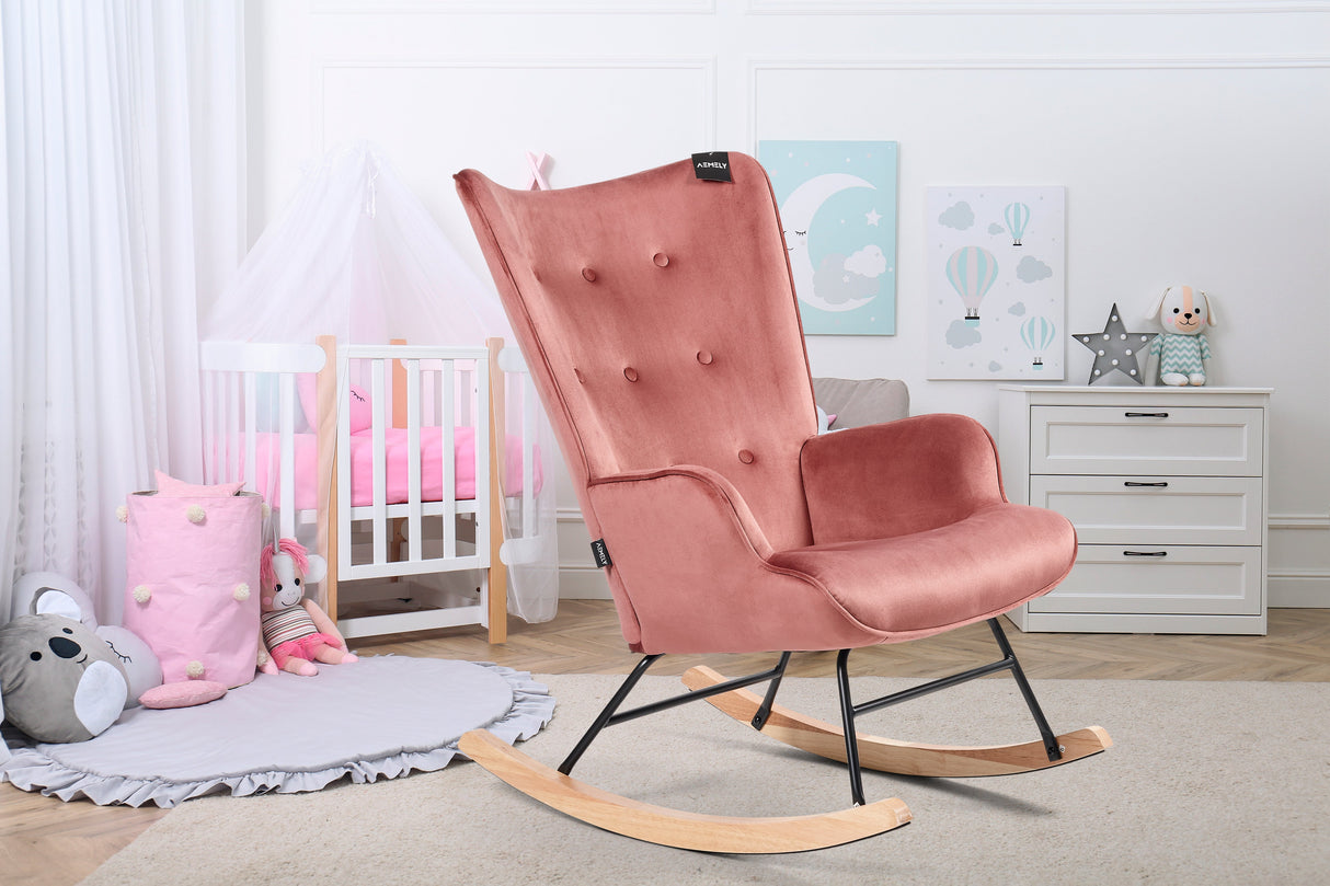 Aemely® Schommelstoel 'Steerne' in roze velvet met beukenhouten poten, geplaatst in een stijlvolle kinderkamer naast een witte ladekast en decoratieve elementen.