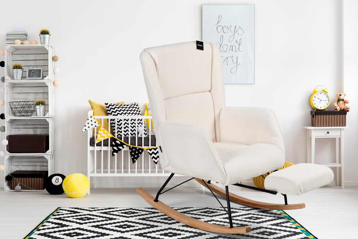 Aemely Schommelstoel Relax - Wit Teddy, Zwarte Poten in moderne kinderkamer met bijpassende voetensteun en geometrisch vloerkleed. Comfortabel en stijlvol meubel.