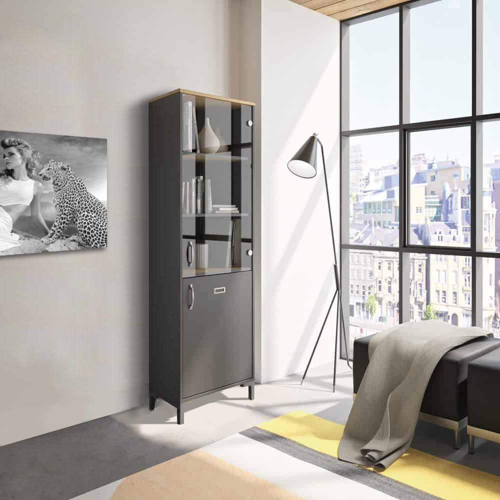 Manchester Vitrinekast 2-deurs - Zwart / Eiken Look in een stijlvolle kamer, met een grote glazen deur en een minimalistische uitstraling.