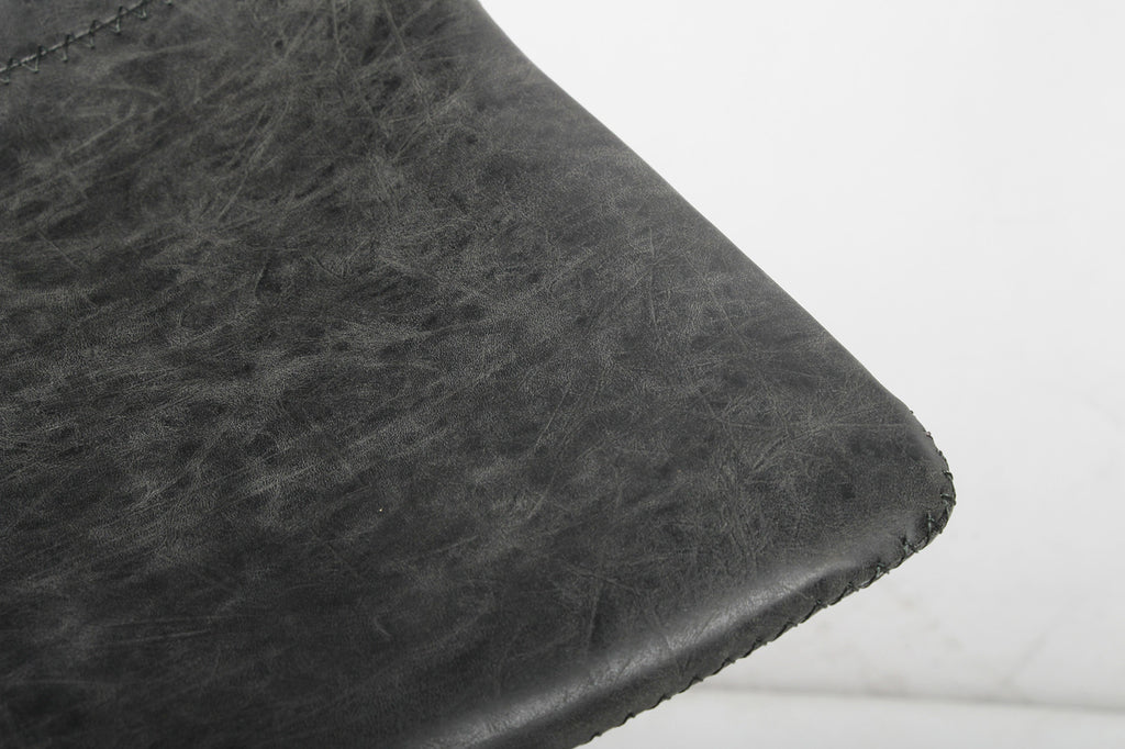 Zwarte PU-leren barkruk 'Ozan' met robuust metalen onderstel, geschikt voor moderne, industriële interieurs. Ergonomisch ontwerp voor comfort. Geschikt voor bartafels.