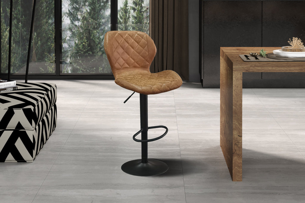 Twee Barkrukken 'Malaga' PU Cognac met metalen poten, geplaatst in een kamer voor een raam, ideaal voor moderne interieurinrichting.