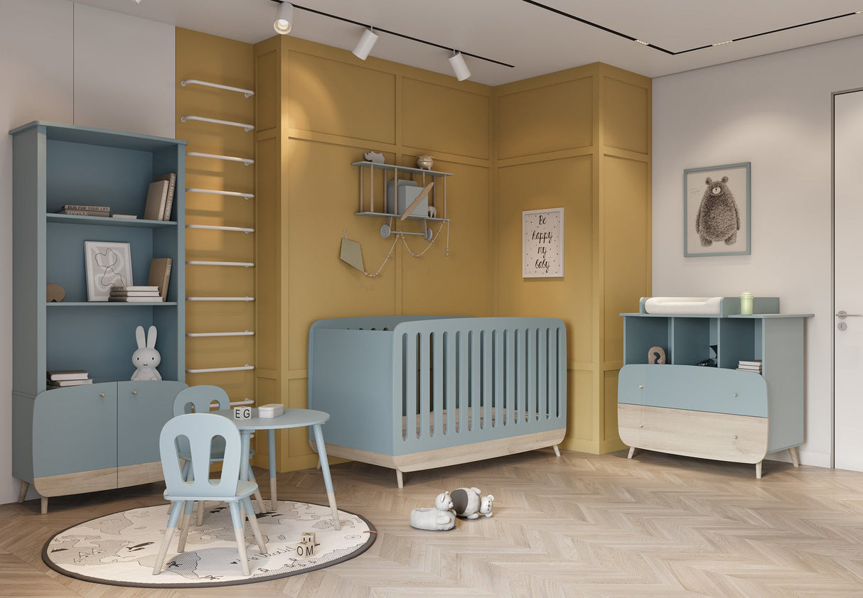 Kledingkast Firmiana Blauw in kinderkamer met speels ontwerp, perfect voor opslag en decoratie, naast een blauw ledikant en een witte stoel.