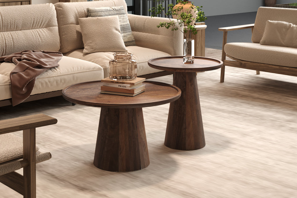 Salontafel 'Jules' 45x50 cm, rond, gemaakt van massief mango hout, lichtbruin, met boeken en een glazen pot erop.