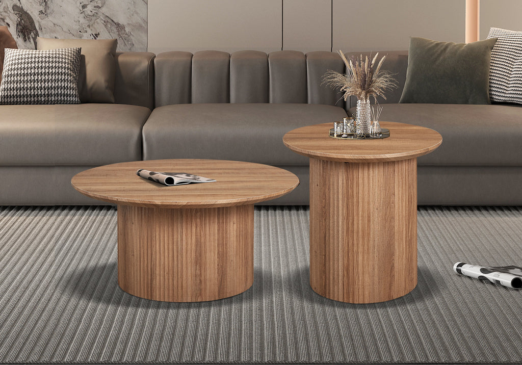 Salontafel 'Lagos' 80 cm Rond Decor Oude Eik, geplaatst in een woonkamer, met tijdschrift en glazen op twee houten tafels.