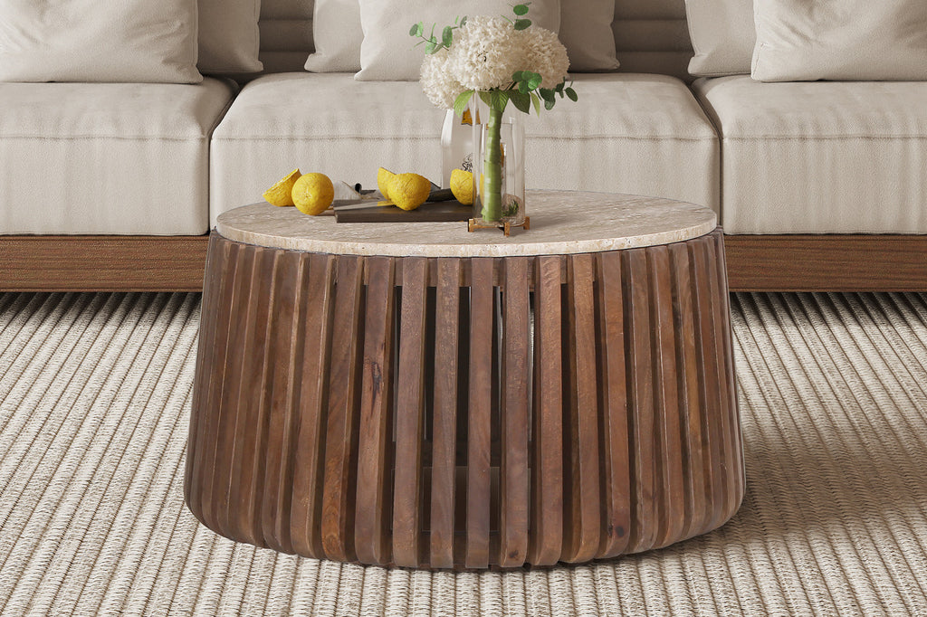 Salontafel 'Luuk' 70 cm rond, gemaakt van mangohout met travertin blad, omringd door een vaas met bloemen en citroenen.