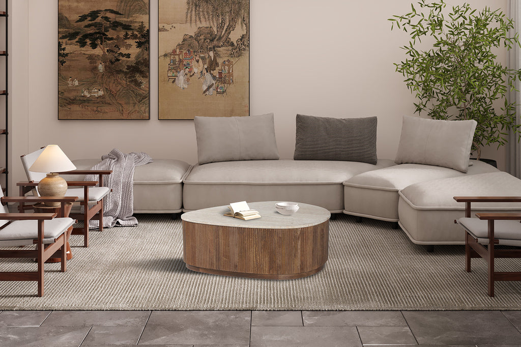 Salontafel 'Nolan' 100 cm van Mango Hout met Travertin, centraal geplaatst in een sfeervolle woonkamer met bank, kussens en planten.