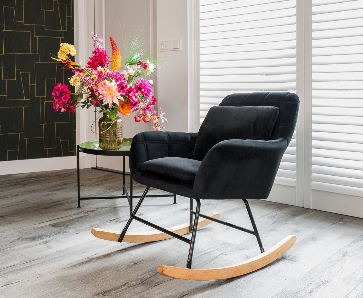 Aemely® Schommelstoel 'Sofie' in zwart velvet, naast een bloemenvaas, biedt compact comfort, ideaal voor kleine ruimtes zoals baby- of woonkamer.