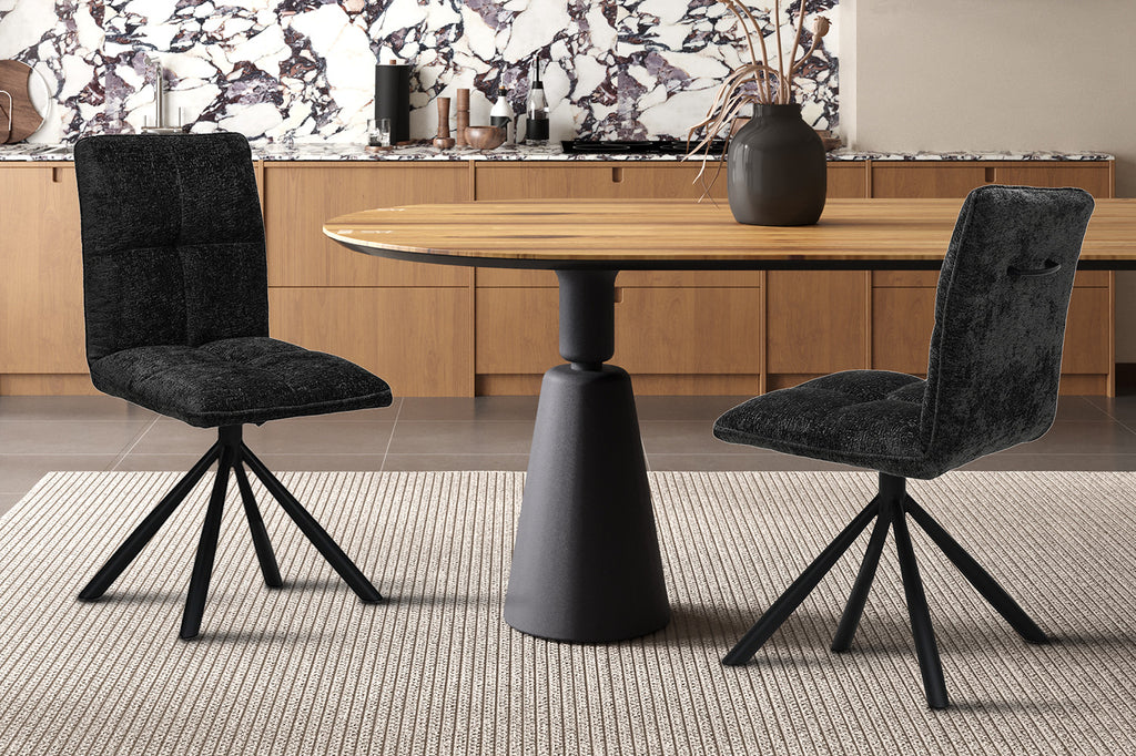 Stoel 'Jack' Draaibaar tot 0 Stof Donkergrijs, geplaatst voor een marmeren muur, naast een houten tafel en vaas met gedroogde bloemen.