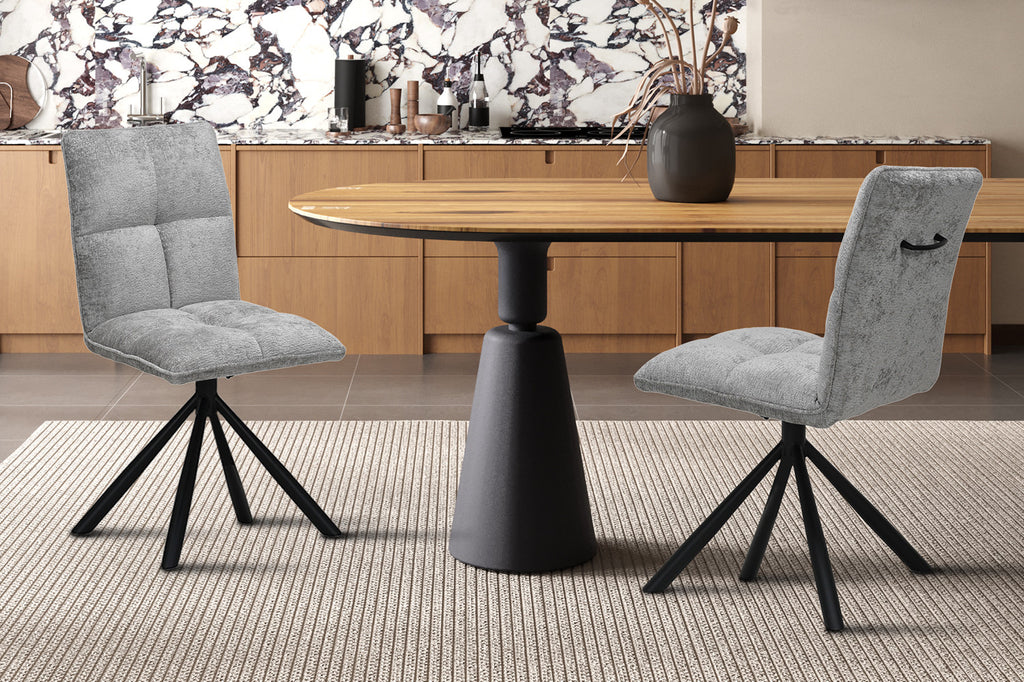 Stoel 'Jack' Draaibaar tot 0 Stof Lichtgrijs met zwarte poten, geplaatst voor een marmeren aanrecht en naast een vaas met gedroogde bloemen.