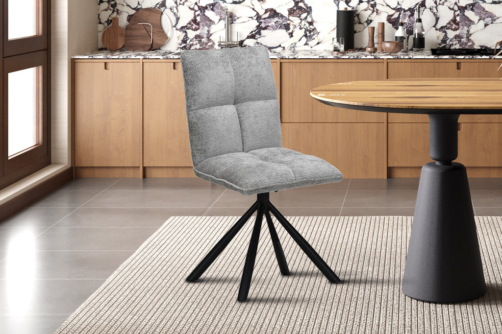 Stoel 'Jack' draaibaar, lichtgrijs met zwarte poten, geplaatst in een keuken naast een tafel. Perfect voor moderne interieurstijlen.