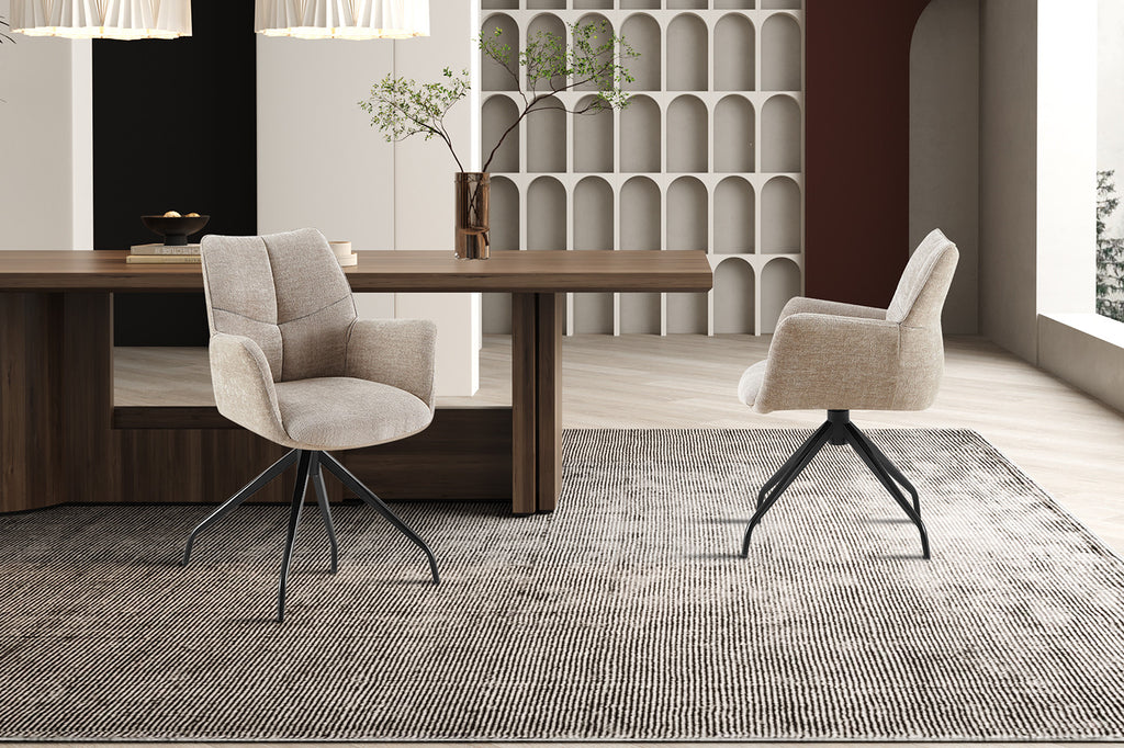 Stoel 'Lamor' draaibaar met metalen poten en stoffen bekleding, naast een tafel in een stijlvol ingerichte kamer.