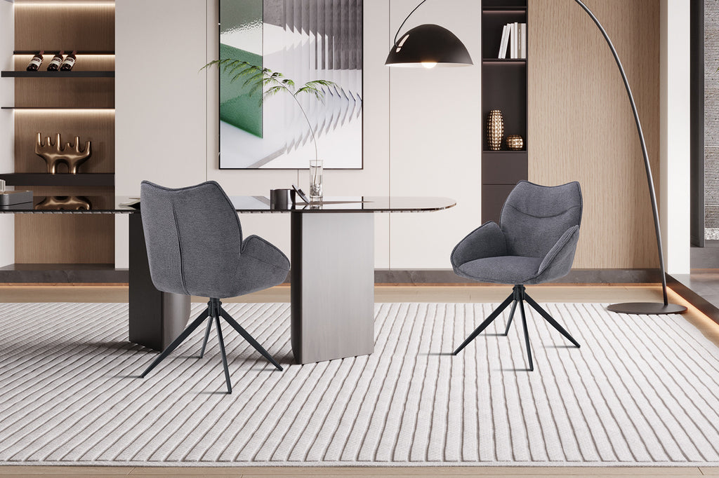 Draaibare stoel 'Mahi' met metalen poten en stofbekleding, donkergrijs, geplaatst naast een tafel in een ingerichte kamer.