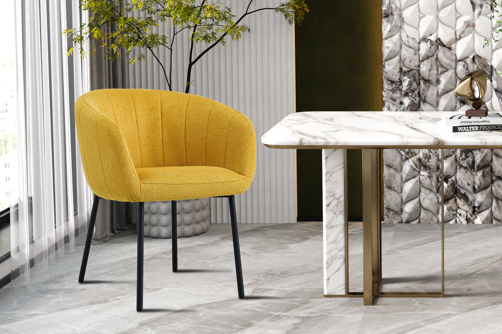 Stoel 'Sevilla' Stof Geel naast een marmeren tafel met gouden poten, perfect voor stijlvolle woonruimtes. Te koop per twee in doos.