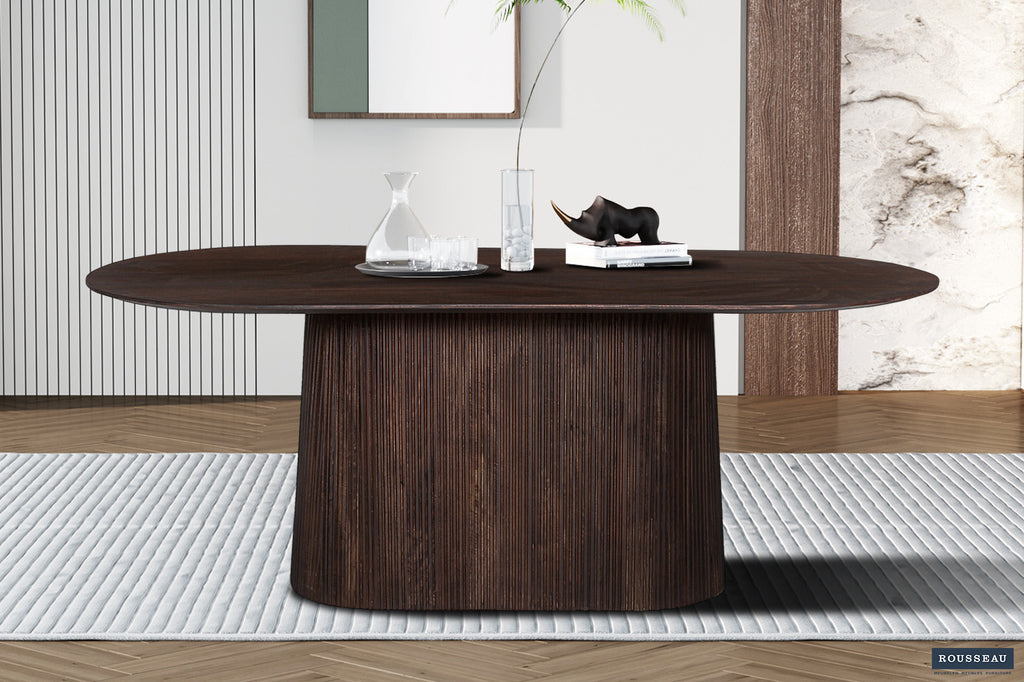 Tafel 'Miguel' 200 cm ovaal van donkerbruin mangohout, met een vaas erop; te zien in een interieur met houten en marmeren elementen.