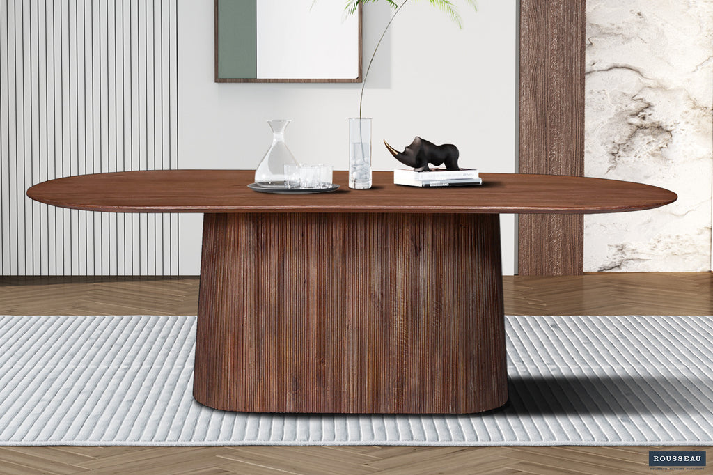 Tafel 'Miguel' 230 cm ovaal, gemaakt van massief mango hout. Te zien met een vaas en een zwart beeld als decoratie.