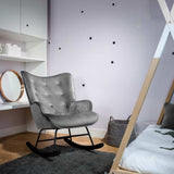 Aemely® Schommelstoel 'Steerne' in grijs velvet met zwart houten poten, geplaatst in een stijlvolle kamer naast een bed en ronde spiegel.