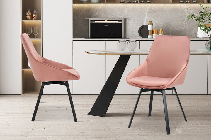 SALE - Stoel 'Mathias' Draaibaar Fluweel Roze, met zwarte poten, geplaatst in keukenomgeving voor plank met glazen. Verkrijgbaar per twee stuks.