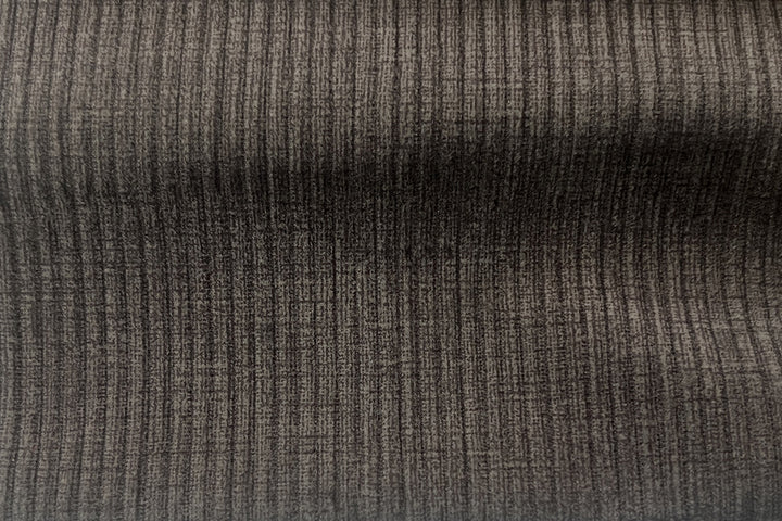Close-up van de grijze ribfluwelen bekleding van de draaibare stoel 'Modest', benadrukt de stoftextuur voor een stijlvolle aanvulling op elk interieur van Furndaily.