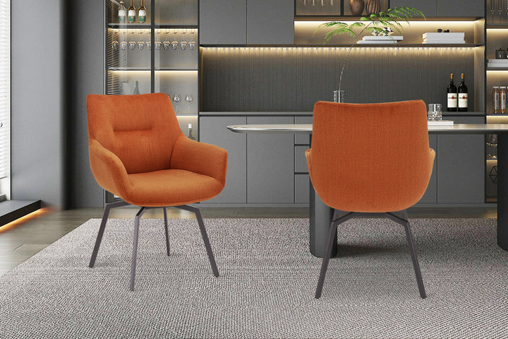 Stoel 'Modest' draaibaar met ribfluwelen bekleding, oranje, geplaatst op een vloerkleed in een ingerichte kamer met metalen vaas en planten op de achtergrond.