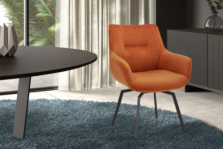 Stoel 'Modest' Draaibaar Ribfluweel Oranje naast een vloerkleed, naast een tafel met vaas, geschikt voor elk interieur.