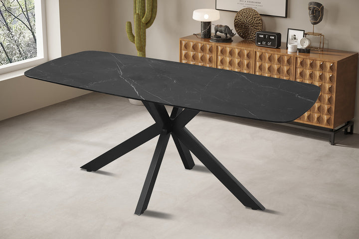 Tafel 'Apollo' 180 cm Deens ovaal, zwart steen met metalen structuur, met accessoires zoals een lamp en klok op het tafelblad.