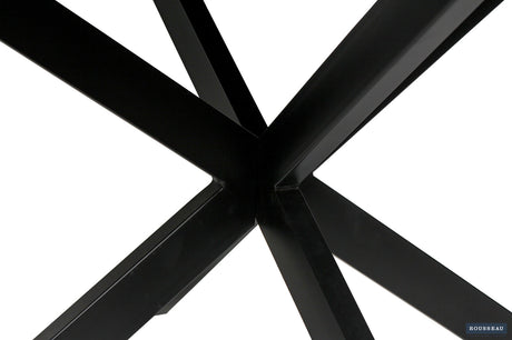 Tafel 'Maria' 130 cm rond met zwart metalen onderstel en exotisch mango houten blad, dicht bij de tafelpoten gefotografeerd.