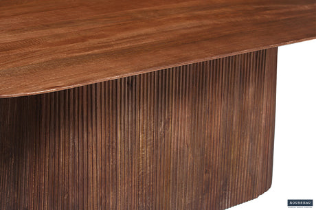 Tafel 'Miguel' 230 cm ovaal, close-up van massief mangohout oppervlak met verfijnde nerf en lichte bruine afwerking, benadrukt vakmanschap en elegantie.
