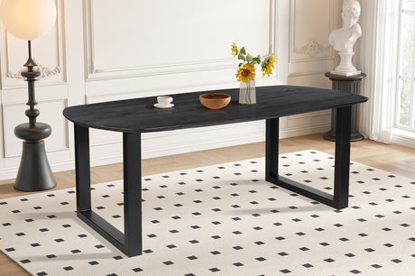 Tafel 'Tommy' 220x100 cm, Deens ovaal met U-poot. Gemaakt van zwart mango hout, met een vaas bloemen en een schaal zonnebloemen erop.